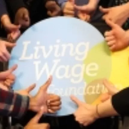 Hands in the shape of a thumbs up gathered around Living Wage Foundation logo
