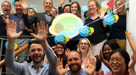 Group of people happy with Living Wage bunting