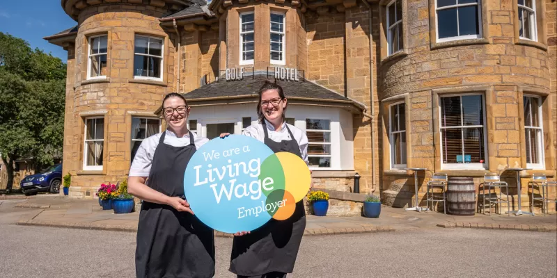 Highland hotel staff with living wage logo