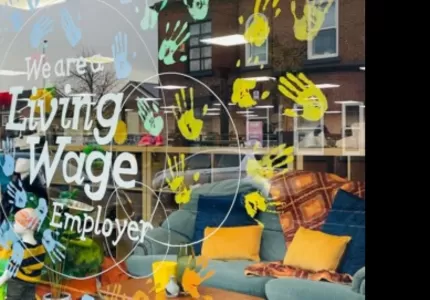 Renewal NW's window display. The Living Wage Logo with handprints