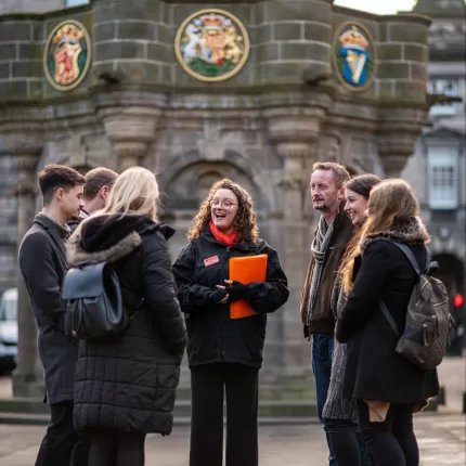 Group of people standing outside an Edinburgh landmark with a tour guide