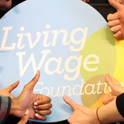 Thumbs around the Living Wage Foundation logo