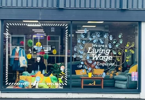 Renewal NW's window, with the Living Wage logo and handprints