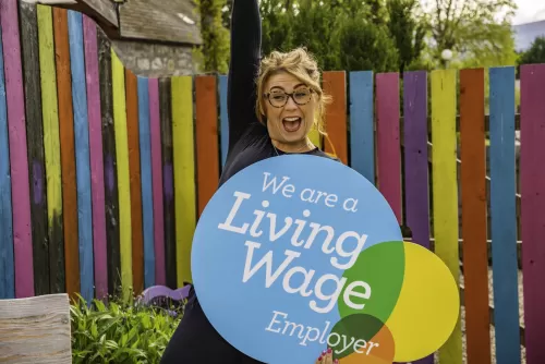 Woman holding Living Wage logo